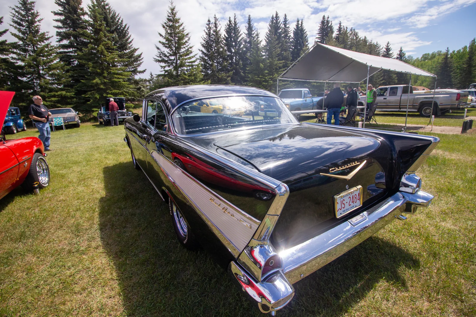 A black 1957 Chevy with tail fins at the car show