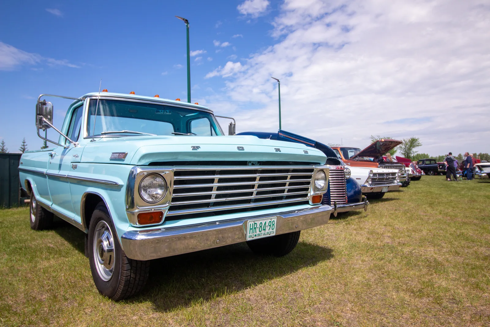 A light-blue vintage Ford pickup at the car show